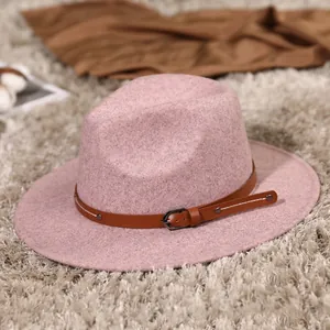 Elegant pink wool fedora hat with brown leather belt buckle on a soft plush rug