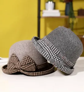 Close-up of wool felt bucket hat featuring vintage check patterns and decorative bow detail