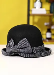 Detailed view of women's black wool felt cloche hat with a gray plaid ribbon bow accent