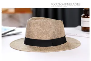 Detailed close-up of khaki straw Panama hat with black ribbon on minimalist background