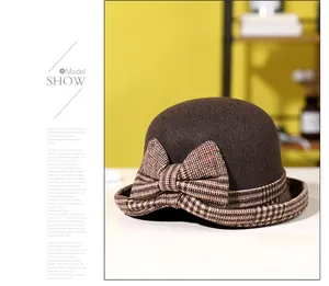 Detail view of a vintage dark brown wool cloche hat with a brown plaid ribbon bow