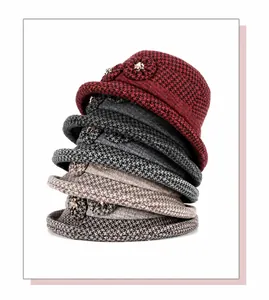 Stack of warm wool felt hats for women with elegant knitted flower detail in various colors