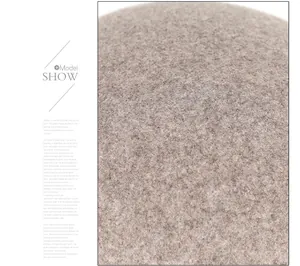 Macro close-up of soft beige wool fabric texture showing detailed weave of the winter hat