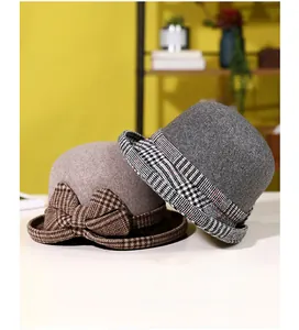 Detail of wool cloche hats in brown and grey with classic plaid bow tie decoration
