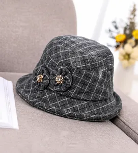 Detailed view of the dark grey plaid wool texture and handmade double flower decor
