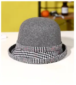 Close-up of grey wool cloche hat featuring a classic houndstooth pattern brim