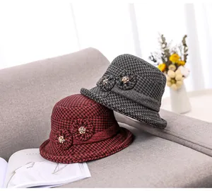 Detail of wool cloche hats for elderly women featuring fabric flowers and rhinestone accents