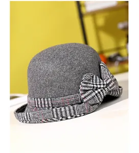 Detail of grey wool cloche hat with a large plaid bow and decorative checkered trim