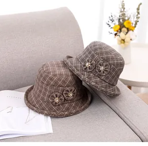 Close-up of brown plaid wool bucket hat with floral detail and rhinestone accents