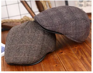 Macro-opname van dikke getextureerde tweed petten met visgraatpatroon en leren bies