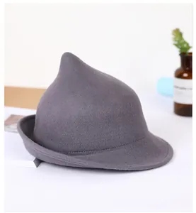 Detailed view of dark grey felt witch hat with pointed crown and rolled brim on a desk