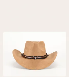 Detail of camel suede cowboy hat with vintage bull skull metal buckle and studded belt