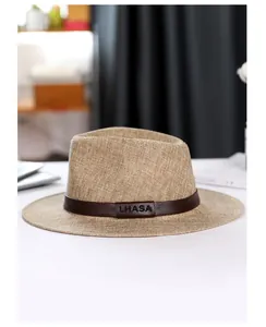 Detail of light brown linen fedora with dark leather band featuring LHASA embossed text