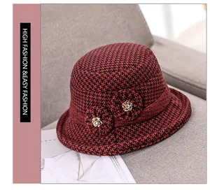 Detail of red and black plaid wool cloche hat with floral accent and metal buttons