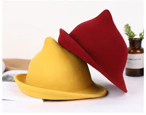 Close-up of pointed wool felt witch hats in yellow and red with curly brim detail