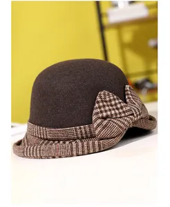 Detail of winter cloche hat with a large brown houndstooth bow and felt texture
