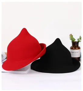Close-up of red and black wool felt witch hats with pointed crowns and curled brims