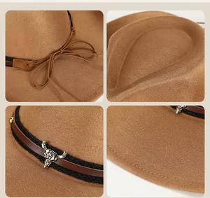 Detail of suede cowboy hat featuring metal bull head accessory and leather strap decor