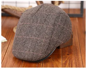 Detail van de dikke tweed pet met rood geruit patroon en warme fleece voering