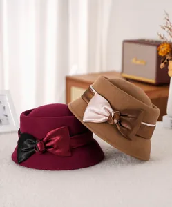 Detail of wool felt dome hats in burgundy and camel with satin bow decoration