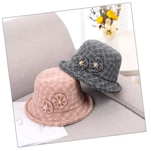 Detail of grey and lotus pink plaid wool fisherman hats with decorative floral accents