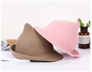 Detailed view of pointed wool felt witch hats in brown and pink on a stylish display