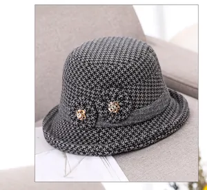 Detailed close-up of the elegant gray tweed winter hat with fabric flower and gold beads