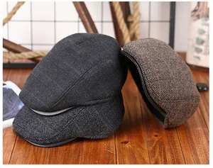 Detail van winterse platte petten in zwart, grijs en bruin getextureerd wolvilt