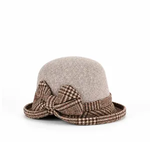 Detailed side view of a gray wool felt cloche hat with a brown plaid bow decoration