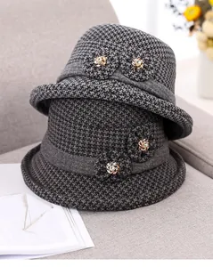 Close-up of thick winter wool cloche hat with fabric flower and gold metal detail