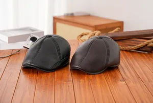 Detailansicht von Retro-Leder-Baskenmützen in Schwarz und Braun mit feiner Naht