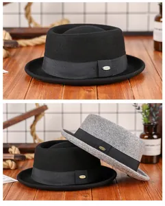 Détail de chapeaux en laine avec ruban gros-grain et logo en métal sur bois rustique