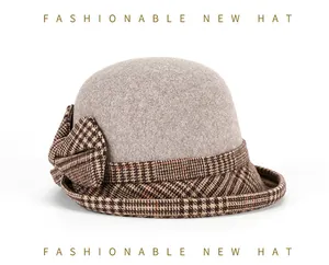 Close-up of grey wool cloche hat with brown plaid bow and refined fabric texture