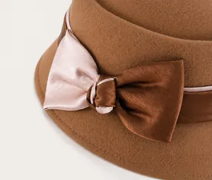 Detailed close-up of a wool felt dome hat featuring a bicolor satin bow decoration