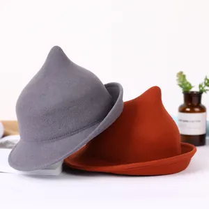 Wool witch hats in grey and rust red colors shown in a minimalist aesthetic setting