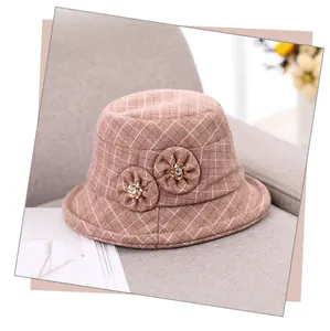 Detail of pink-brown checkered wool bucket hat with fabric flowers and rhinestone accents