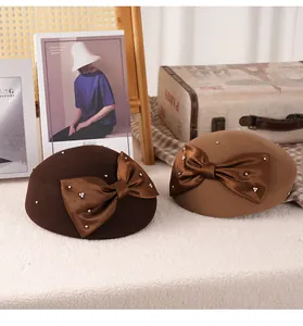 Detail of wool beret hats with elegant satin bows and pearls in brown and khaki