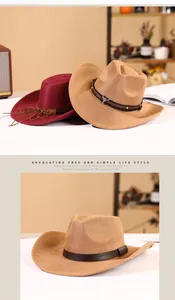 Detail of wide brim faux suede cowboy hat featuring metal bull buckle and studded belt