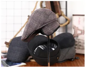 Detail van geruite krantenjongenspet met inklapbare oorflappen voor de winter