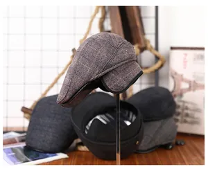 Details van vintage geruite platte petten met opvouwbare oorflappen voor de winter
