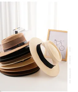 Dettaglio della maglia traspirante e nastro decorativo su cappelli di paglia estivi