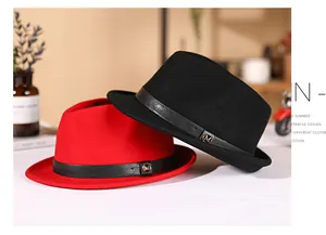 Detail of wool fedora hats with leather bands and gold M metal buckle in red and black