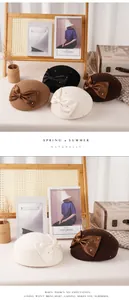 Detail of wool berets with silk bows and pearl embellishments in multiple elegant colors