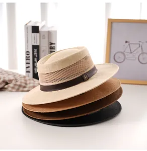 Dettaglio di cappelli di paglia intrecciata con cinturini in pelle e logo M in metallo