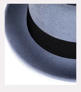 Détail de la texture en feutre de laine et du ruban noir sur un chapeau bleu élégant