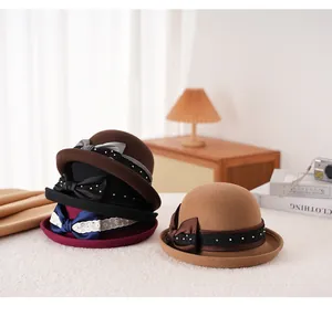 Dettaglio di cappelli cloche in lana con fiocchi, pizzo e perle in diversi colori