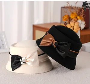 Close-up of wool felt dome hats with elegant satin bows in beige and black colors