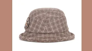Detail of a brown plaid wool bucket hat with side flower petals and metal center button