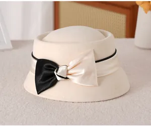 Detail of elegant beige wool felt dome hat featuring a bicolor satin bow ribbon decoration