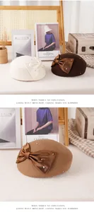 Detail of wool beret featuring elegant silk bow with pearl and rhinestone accents